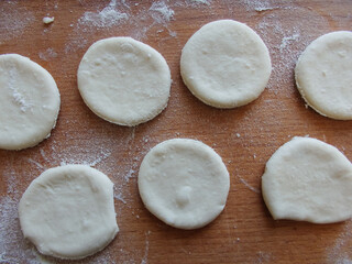 Cooking yeast dough. Working with dough in the kitchen. Close-up on rolled out dough.