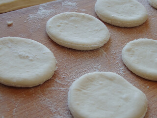 Cooking yeast dough. Working with dough in the kitchen. Close-up on rolled out dough.