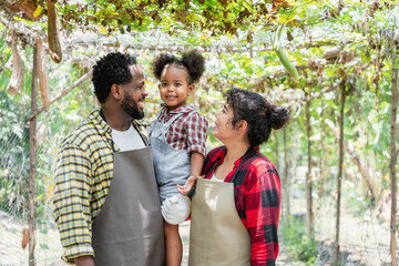 Farming family smiling at the camera while standing on the farm.