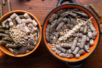 sunflower cake flakes with grass and bran granules and cereals for horses and other domestic animals in bowls. food concept. flat lay