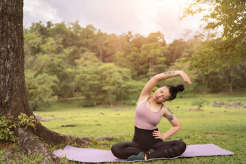 asian tattoo young woman doing yoga in the park