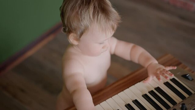 Asian Baby Girl Toddler Playing Electric Piano, Sit Down On The Floor Tapping On Keyboard Music Instrument, Kids Artistry Learning Skills, Happy Healthy Female Child Pretend To Play Music By Herself