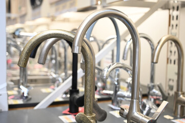 Plumbing and kitchen faucets at exhibition in store. Plumbing shop faucets for the kitchen bath equipment