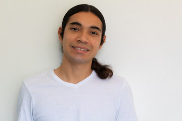 portrait of a non binary hispanic man with long hair on a white background
