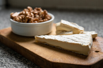 Fototapeta na wymiar Portion of brie cheese accompanied with walnuts