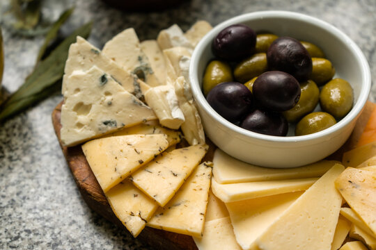 Variety of cheeses with green and black olives