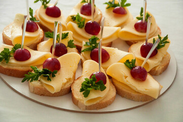 sandwiches with butter cheese and grapes. light breakfast concept. delicious snacks on the festive table.