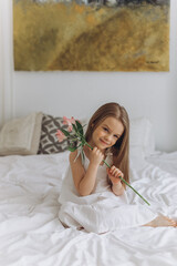 Cute adorable caucasian little girl at home with flowers. Smiling happy kid, childhood happiness concept 