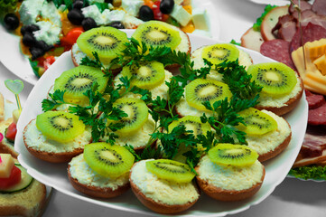 sandwiches with kiwi and grated cheese. healthy food concept. light breakfast illustration. holiday snacks in a white plate.