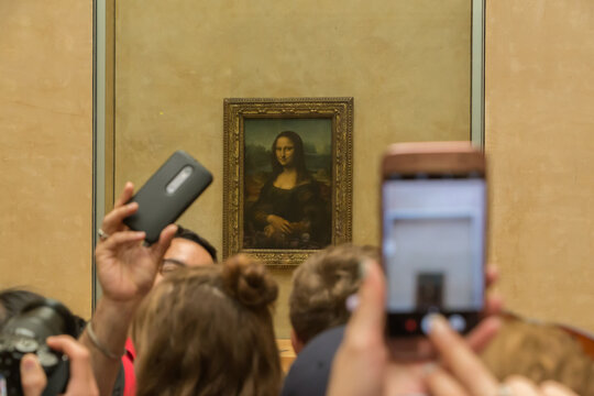 ourists making photos of Mona Lisa painting in Louvre