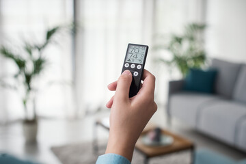 Woman controlling the room temperature remotely