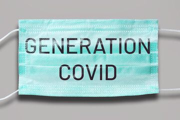 Blue disposable mask with text: GENERATION COVID. Grey background. Covid lockdown. Abstract concept of epidemic era.