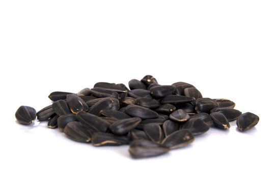 Sunflower seeds isolated on white background. Closeup photo of black sunflower seeds.