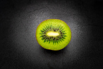 Sliced ​​half kiwi isolated with dark background