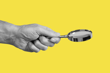 Magnifying glass in man hand on yellow background. Information search and analysis concept....