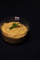 Cheddar cheese sauce for dipping chips bowl in dark background