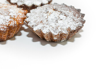Small sweet cupcakes sprinkled with sugar sprinkles on a white background.