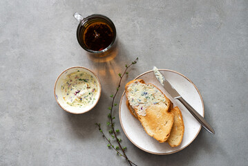 Sandwiches with herbs butter on a gray background. Herb butter in a bowl on concrete background. Healthy homemade herb butter and bread