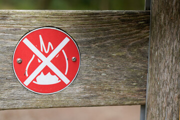 No open fire burning symbol text in wooden panel outdoor park with flame tree