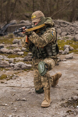 Fototapeta premium Ukrainian soldier of the Armed Forces of Ukraine sits taking aim