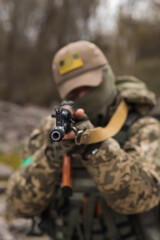 Ukrainian soldier of the Armed Forces of Ukraine sits taking aim