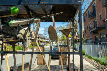 Lanscapers tools racked on the back of a trailer in an older residential neighbourhood.  Shot in the Toronto Beaches in the spring.