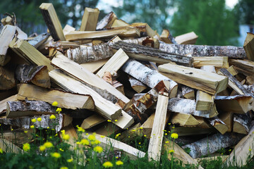 Firewood in a pallet. Chopped firewood lies on the ground. Wooden background..