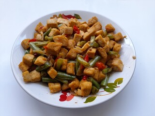 stir fry tofu and green beans on a plate on a white background. healthy food background concept, food recipe, homemade, handmade, vegetable, vegetarian, diet, breakfast,dish,cuisine, meal,lunch,dinner