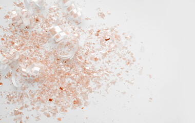 Gold Metallic Confetti and Paper Swilrls on a White Background.Simple Modern Composition with Golden Shimmering Confetti Scattered Confetti ideal for Banner, Card. Top-Down View.No text. Party Layout.