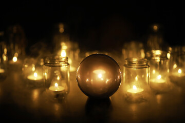 Black background with a ball and candles. Divination and prediction of fate.