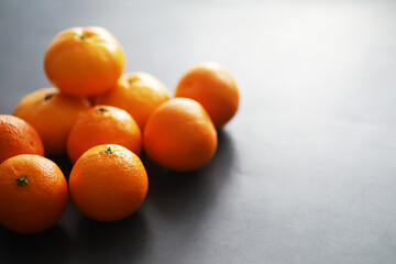 Citrus fruits on a gray background. Tangerines with leaves. Christmas fruit.
