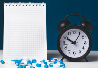 Time to take your medicine. Pill reminder. Tablets and alarm clock.