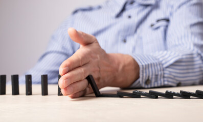 Business hand stop, preventing domino falling. Risk, fear, insurance concept. Disaster crisis...