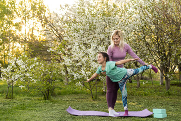 two young women and a little girl in their garden doing yoga