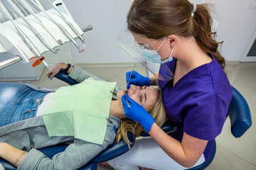 in a specialized dental clinic, a female dentist receives clients with problem teeth.