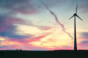 wind farm windmills in dramatic light and mystical sunset atmosphere