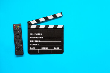 Clapper board and a tv remote controller isolated on red background. Film production, movie shooting and watching movie concept. 