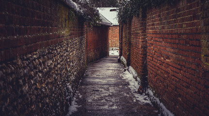Brick alleyway on a snowy and damp day