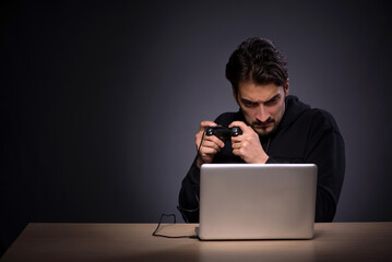Young male gamer on grey background
