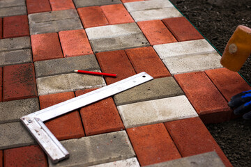Close-up of a builder installing and laying paving stones on a terrace