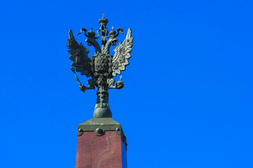 Statue of a two-headed eagle against a blue sky. The symbol of the Russian state on Troitsky bridge