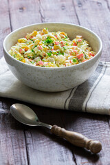 Vegetable salad with crab sticks, dressed with mayonnaise.