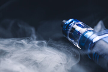 Vape on a black background in smoke, an electronic cigarette for smoking nicotine, a lot of steam...