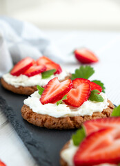 Healthy toast with strawberry, cream cheese and mint leaf. Tasty breakfast. Clean eating, dieting or recipe of healthy snack sandwich for vegetarian. Restaurant serving on slate board.
