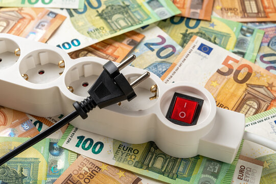 Switched Off White Power Strip And Unplugged Black Electric Plug Over Euro Banknotes Background. Inflation And Power Crisis Concepts. Increasing The Energy Costs, Save Electricity.