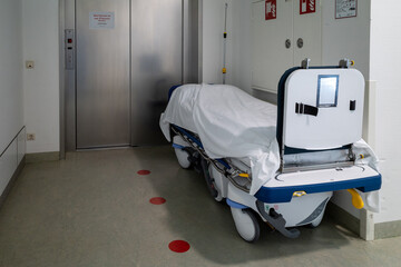 patient transport bed stands in front of an elevator in a hospital