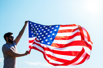 proud strong american man waving USA united state flag against blue sky. Happy Memorial Day	
