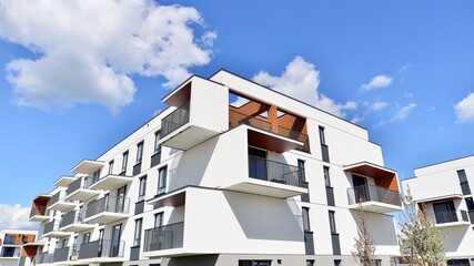 Part of a white residential building  with balconies and blue sky with clouds. Architectural...