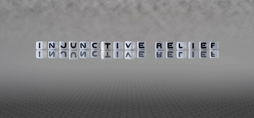 injunctive relief word or concept represented by black and white letter cubes on a grey horizon...