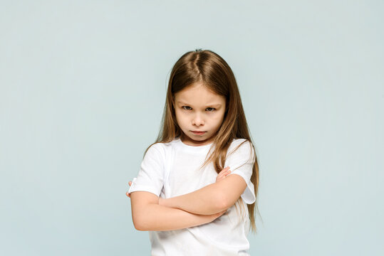 Photo of unhappy sad upset little girl feeling bored offended isolated on blue background